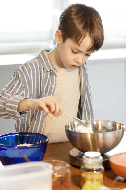 istock 7 year old boy cooks food independently at home 2192712498