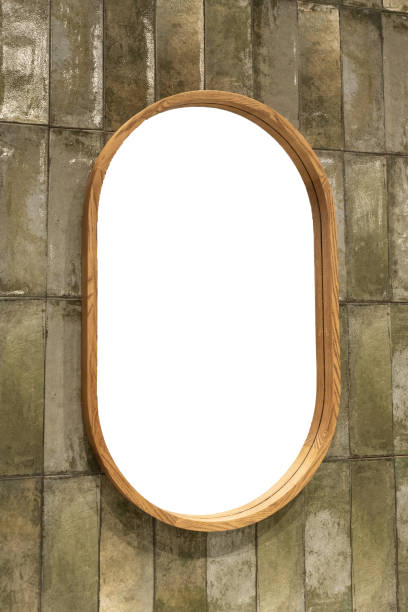 istock Oval wooden mirror mounted on a green tile wall 2192715360
