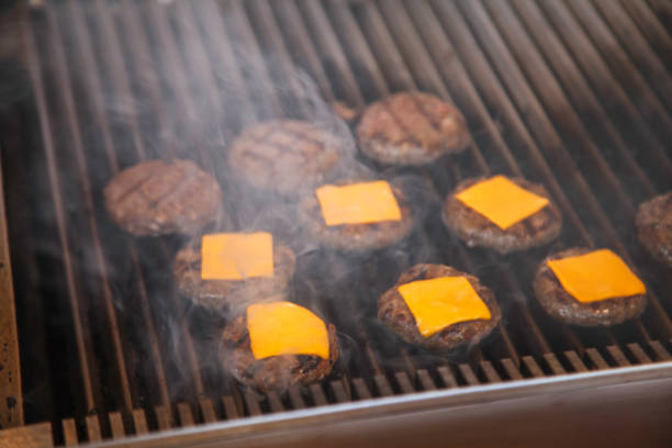istock Cheeseburgers Grilling with Melting Cheese on Smoky Barbecue 2192715748