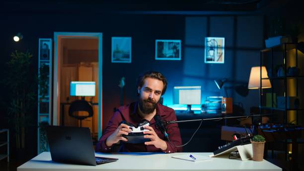 istock Tech vlogger reviewing VR goggles in neon lit studio 2192718233