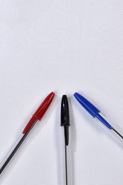 set of blue ballpoint pens lined up hardly on a white background
