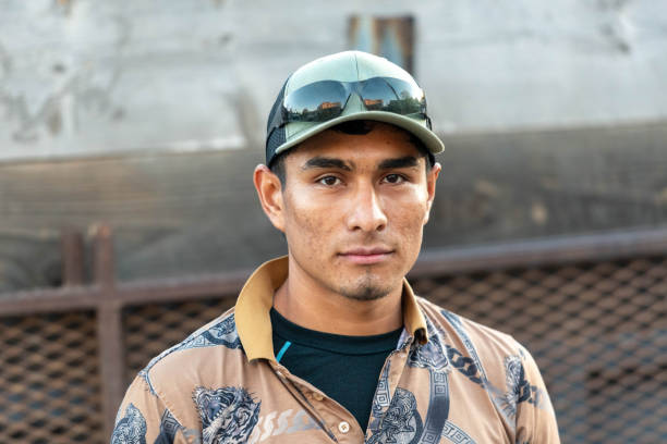 Young hispanic man looking at the camera wearing a cap