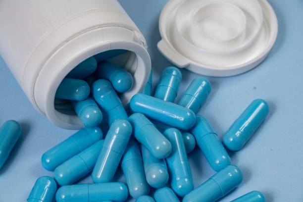 istock bottle of pills, some of which spilled onto a light blue surface 2192731343