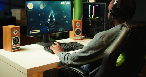 istock Gamer using headphones to discuss with mates while playing SF game, close up 2192733021