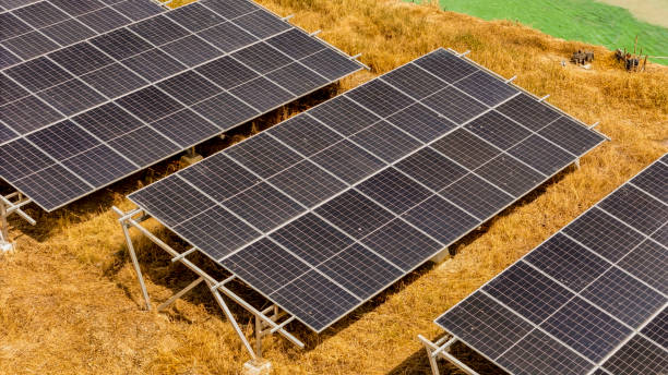 istock Top view of solar arrays with a bright green waterbody and technicians, representing progress in renewable energy and the harmony between modern technology and environmental conservation. 2192734964