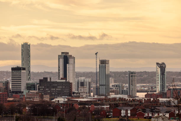 A vibrant view of Liverpool's modern skyline during the golden hour, with the soft warm hues of the sky casting a golden glow over the high-rise buildings. This image highlights the city’s evolving urban architecture, blending contemporary structures with its historic charm. The warm tones of the sky create a serene and captivating atmosphere, showcasing Liverpool’s beauty at dusk.