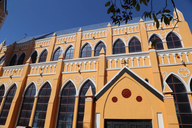 istock A large church building with an orange exterior wall, adorned with white decorative elements and arched windows that give it a unique appearance 2192752077