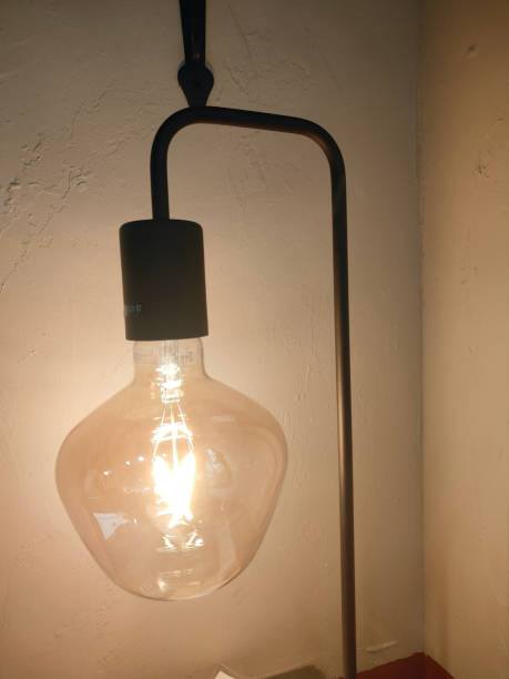 istock A large light bulb is hanging on the wall, and an iron pipe sticks out from under it to support its weight 2192753036