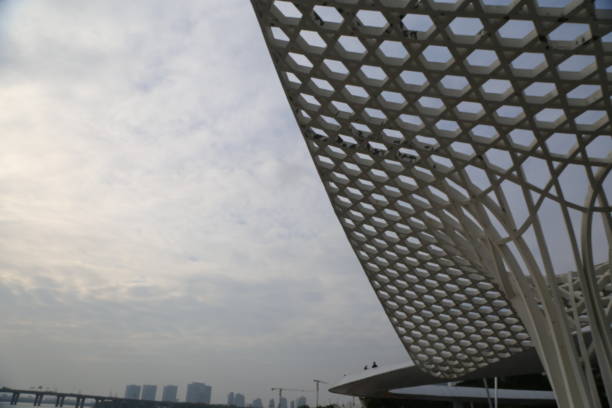 The sky is cloudy and the sun is not visible. The building has a lot of windows and a lot of light is coming through them