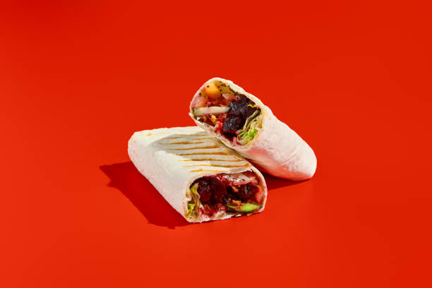 istock Vegetarian shawarma with vegetables and beet on a red background. A healthy and eco-friendly alternative to traditional shawarma. Modern, minimalist food photography, side view 2192756363