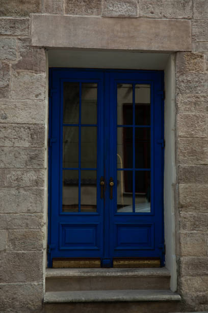 Brick building facade, steps and blue doors outdoors