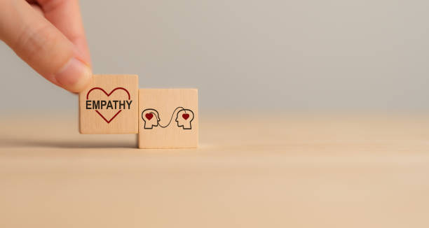 istock Empathy concept. Wooden blocks with empathy icons on minimal background and copy space. The power of emotional intelligent, soft skill development. Empathy in the workplace, good leaders, good teams. 2192759341
