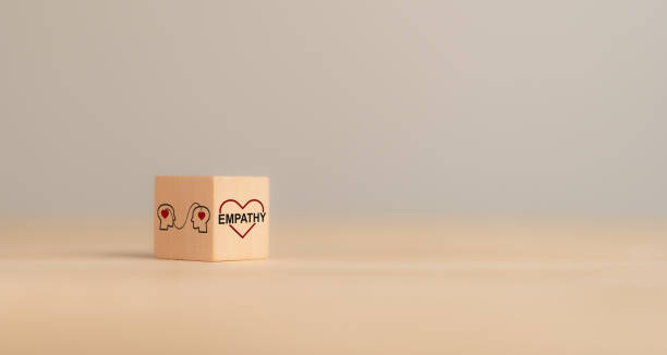 istock Empathy concept. Wooden blocks with empathy icons on minimal background and copy space. The power of emotional intelligent, soft skill development. Empathy in the workplace, good leaders, good teams. 2192759342