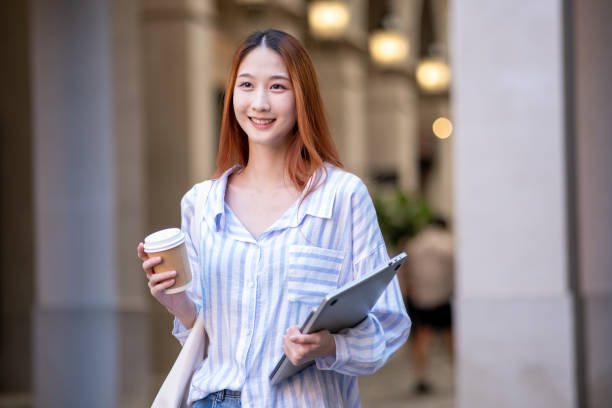 istock Woman is holding a cup and a tablet 2192761631