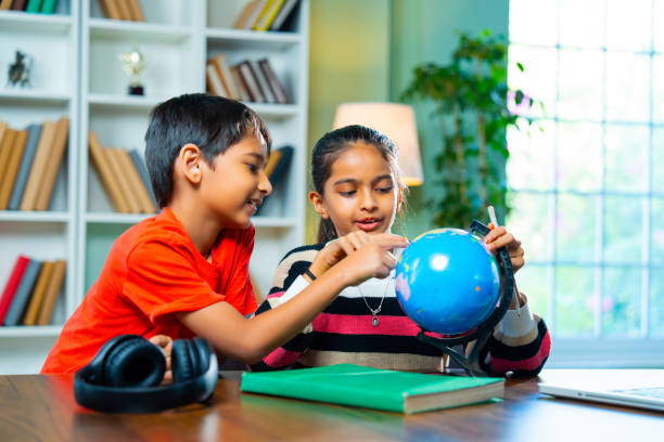 istock Indian siblings playing with an educational globe at home, discovering countries in a playful way 2192763762