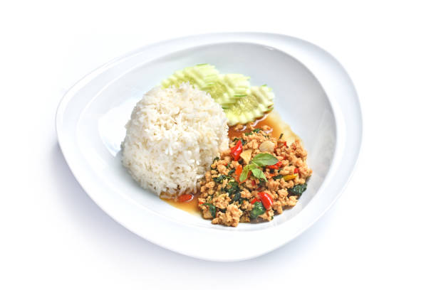 Stir-fried Chicken and basil in white plate with cooked rice, top view