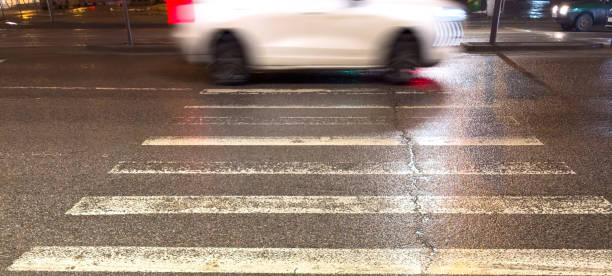 istock A car is driving down a street with a crosswalk 2192769260