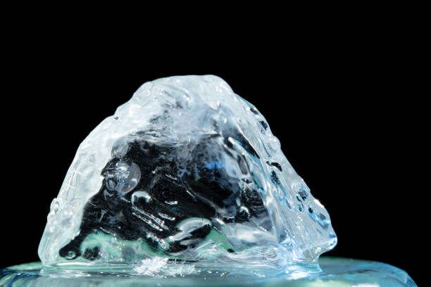 Ice macro closeup captures surface pattern of transparent ice crystal. Frigid background reflects the intense cold. Water transformed into frost ice creates cracked, abstract beautiful texture