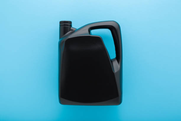 istock 5L dark black plastic container for car motor oil on light blue table background. Pastel color. Closeup. Empty place for text or logo on can. Top down view. 2192771799