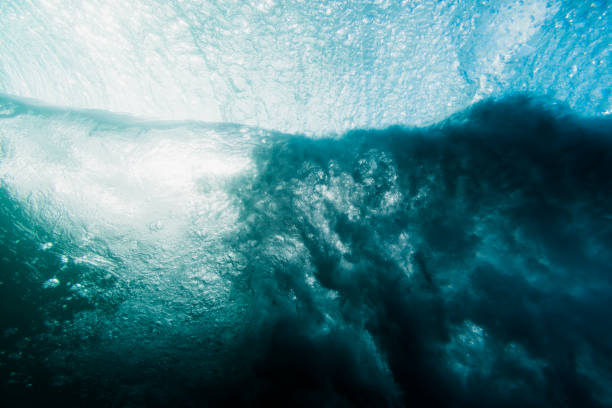 Ocean wave with foam in underwater. Sea water textures underwater