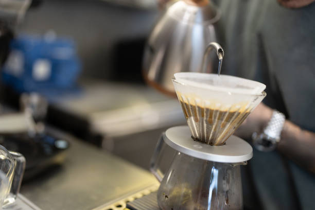 Pouring method of water over filtered roasted and ground coffee beans for brewing drip filter coffee