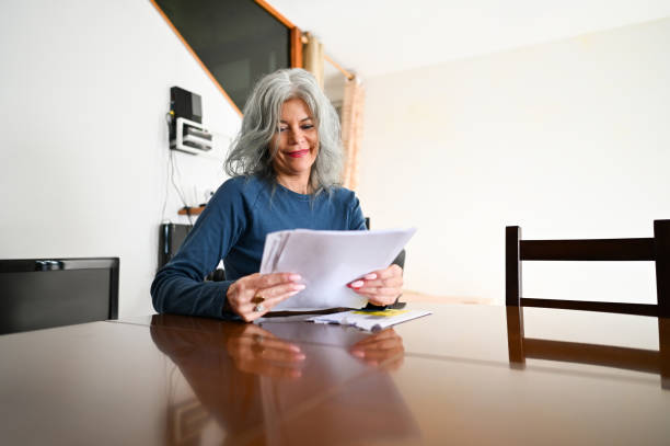 istock Senior woman examining documents at home. 2192778318