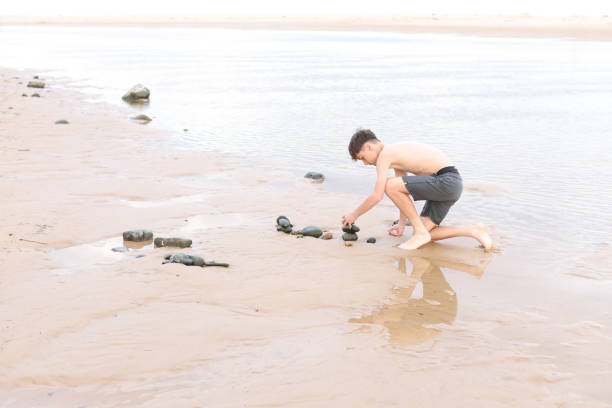 istock Teenage boy building a cairn 2192779520