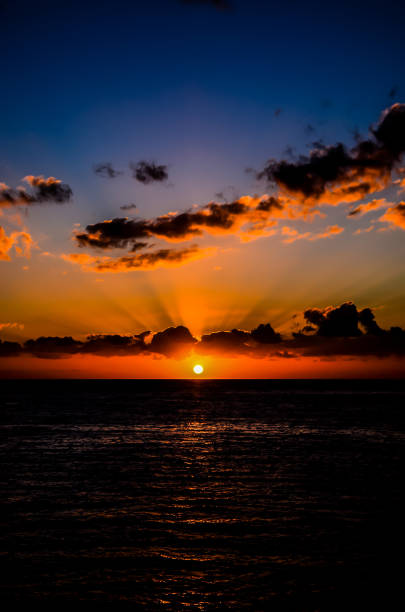 istock The sun is setting over the ocean, casting a warm glow on the water 2192780289