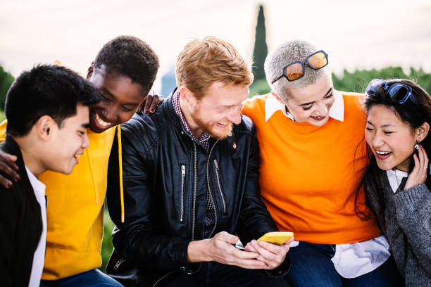 istock Young group of multiracial student friends having fun using smartphone together outside 2192780430