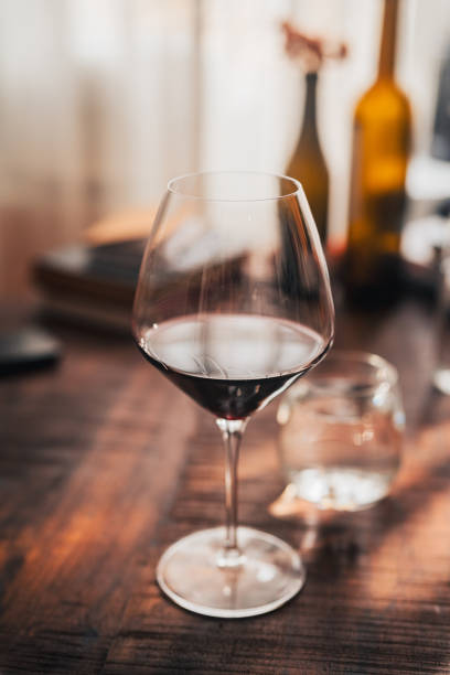 istock Red wine in glass on wooden table creating solitude in cozy home setting 2192781110