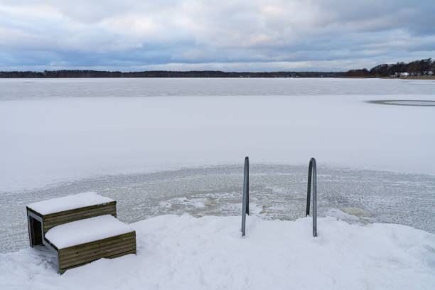 A ladder into an ice hole for winter swimming. Hardening, winter swimming, health, ice water, extreme, active lifestyle, traditions. Estonian nature.