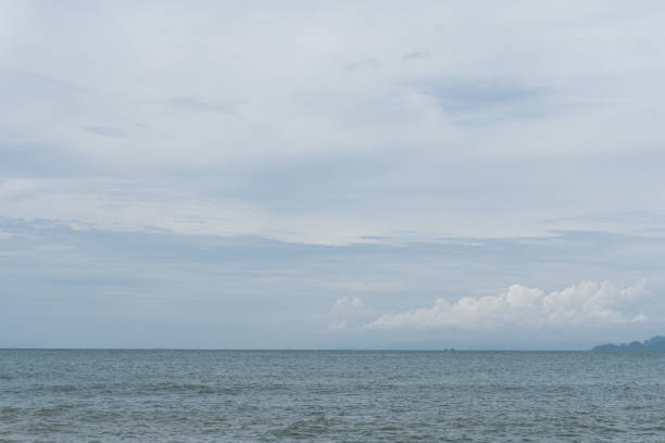 A serene seascape with calm ocean waters and a cloudy sky, evoking tranquility and peacefulness.