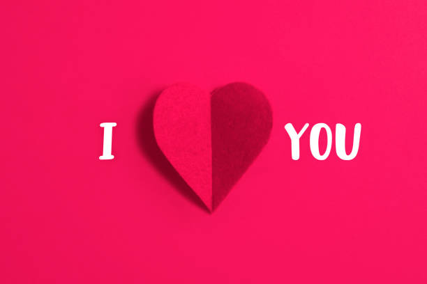 I Love You phrase and red heart shaped textile on pink background