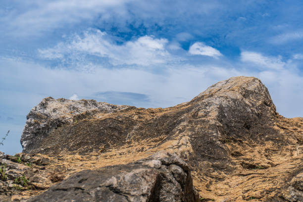 istock A rocky outcrop with a clear blue sky with a few clouds in the background. 2192790964