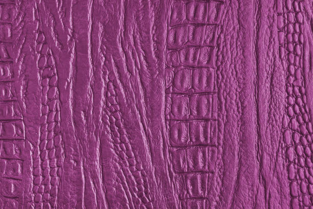 Crocodile genuine leather structure texture macro, pink colored leatherette surface with metallic, pearlescent effect. Reptile skin close up, macro background, wallpaper, backdrop