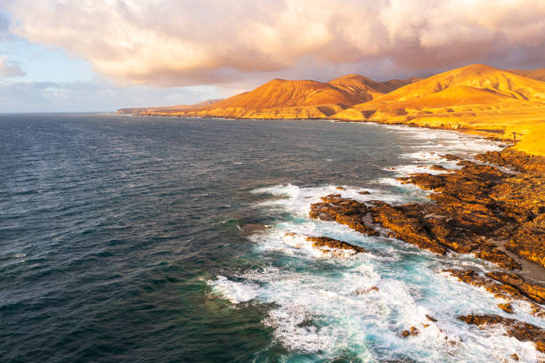 istock Volcanic coast washed by the ocean waves at sunset 2192791283
