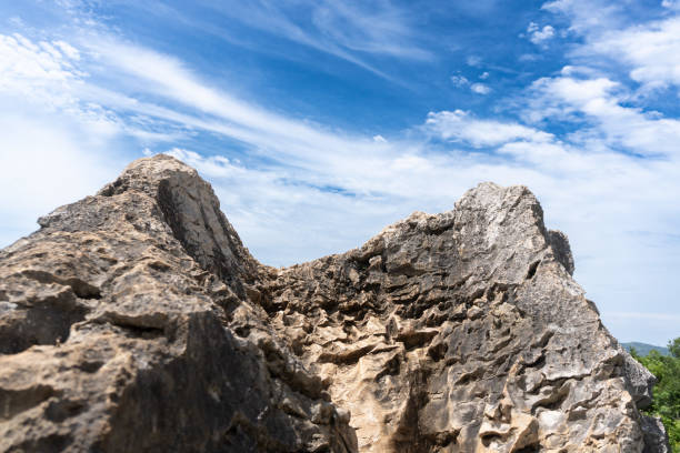 istock A rocky outcrop sits beneath a blue sky with wispy clouds, showcasing natural textures and colors. 2192791395