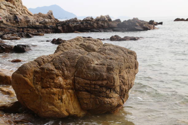istock A large rock sits on the beach next to the ocean 2192792229