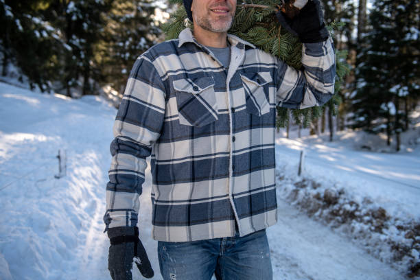 istock Man carrying a Christmas tree through a snowy forest 2192792660
