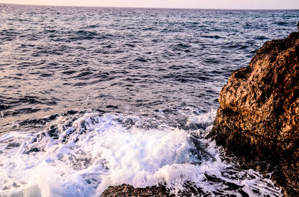 The ocean is calm and the water is a deep blue color. The waves are small and the water is still