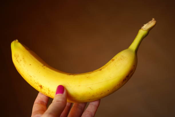 istock banana fruit in female hand 2192797707