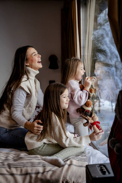 istock Girls playing together on bed next to window 2192799760