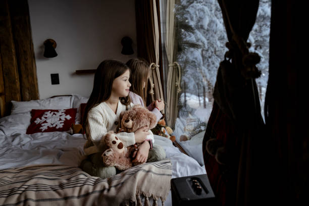 istock Girls playing together on bed next to window 2192799837