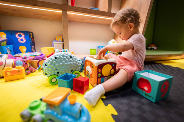 istock Toddler engaged with building blocks and interactive toys in a cheerful play area 2192800536