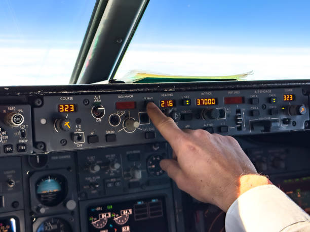 pilot setting or adjusting autopilot in passenger airplane in flight - autopilot stock-fotos und bilder