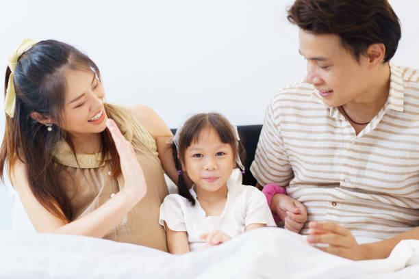 istock Happy Asian family relaxing together on a bed. 2192809475