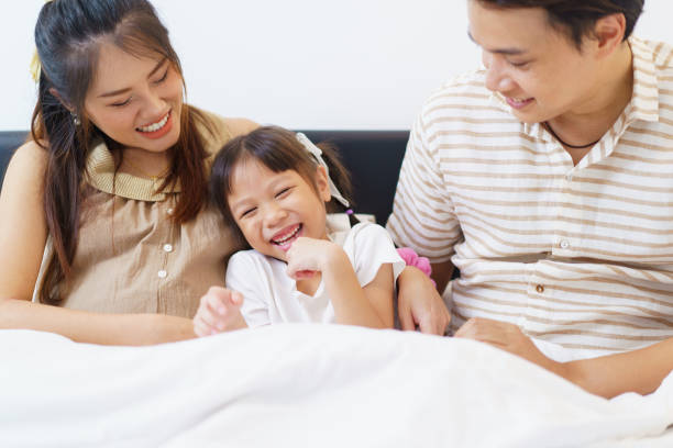 istock Happy Asian family relaxing together on a bed. 2192809486