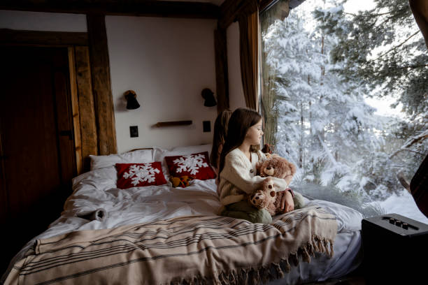 istock Little girl playing with teddy bear in log cabin 2192810057