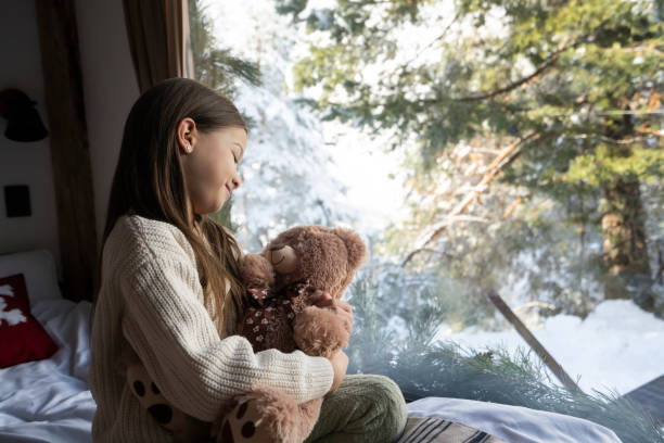 istock Little girl playing with teddy bear in log cabin 2192810066