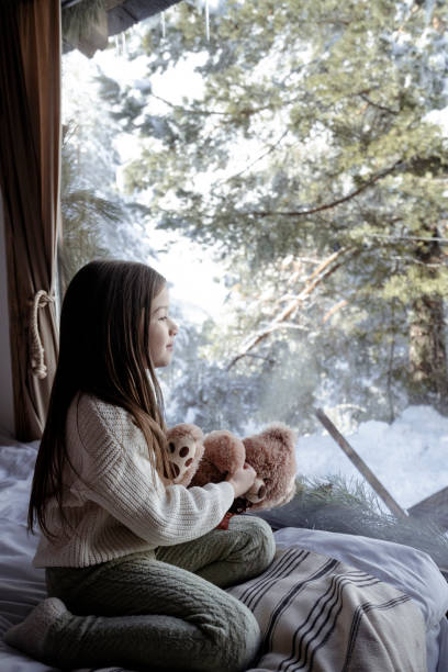 istock Little girl playing with teddy bear in log cabin 2192810298